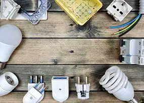 LED-Lampe, Kabel und weiteres Zubehör auf einem Holzbrett. 